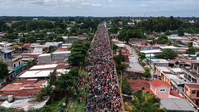 TOPSHOT - Aerial view of a Honduran migrant caravan heading to the US, as it reaches the Guatemala-Mexico international bridge in Tecun Uman, Guatemala on October 19, 2018. Honduran migrants who have made their way through Central America were gathering at Guatemala's northern border with Mexico on Friday, despite President Donald Trump's threat to deploy the military to stop them entering the United States. / AFP / Carlos ALONZO
