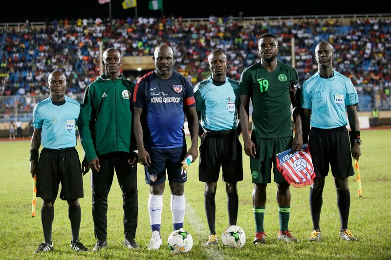 George Weah poses with players and referees prior to the kick off. EPA