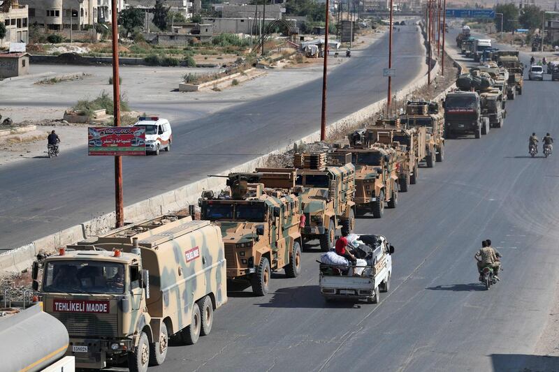 Inhabitants of Maaret Al Numan in Syria's northern province of Idlib watch a convoy of Turkish military vehicles reportedly headed to assist rebels against regime forces.  AFP