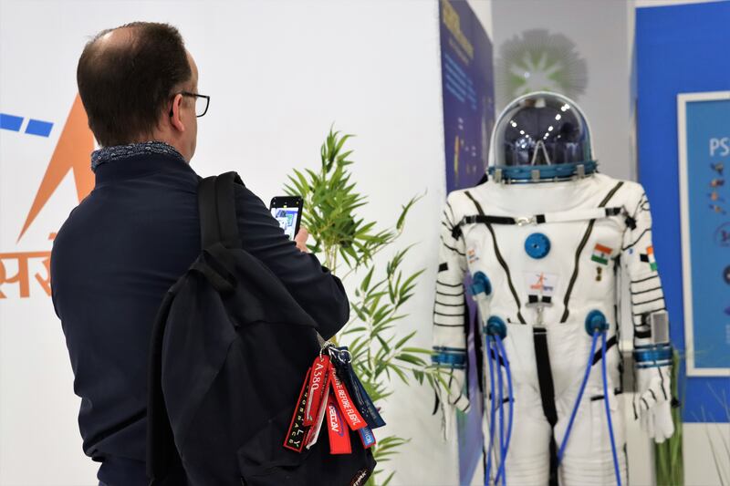 A visitor takes a photo of a spacesuit that Indian astronauts will wear one day.