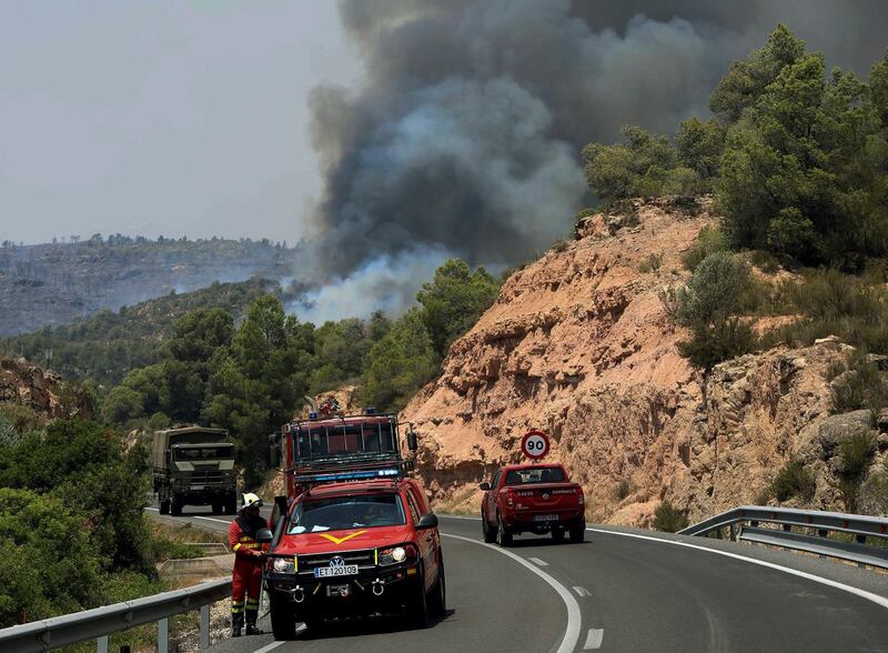 Emergency vehicles are seen near a forest fire. EPA