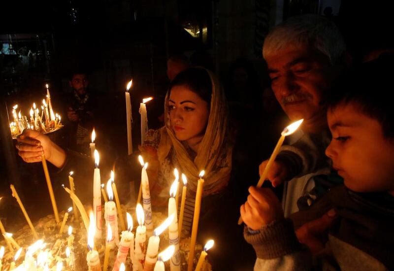 Christian worshipers light candles inside the Church of the Nativity in Bethlehem. Mussa Qawasma / Reuters

