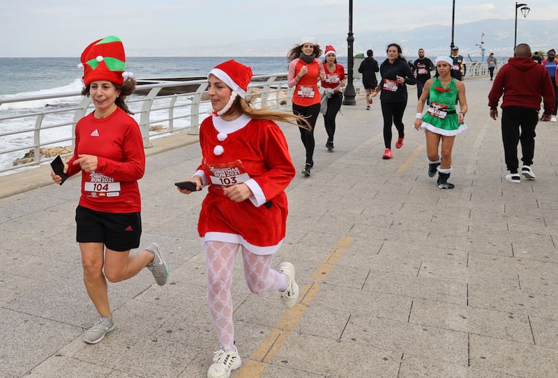 People wearing festive hats take part in a Christmas run along the corniche in Beirut. AFP