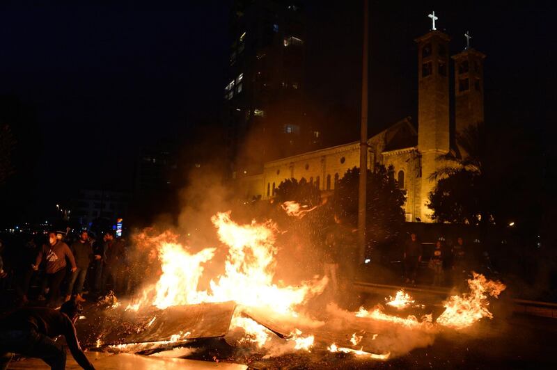 Protesters burn dumpsters as they block the road near the Maronite Catholic Church of Saint Maroun during ongoing protests in Beirut. EPA