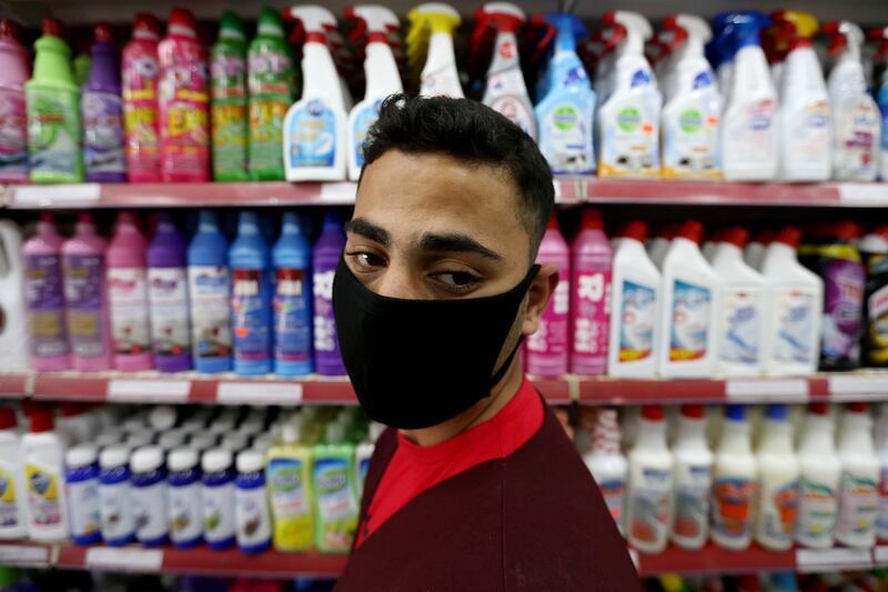 A Palestinian man wearing a mask looks on as he stands in front of disinfectants and cleaning products at a supermarket in the southern Gaza Strip. Reuters