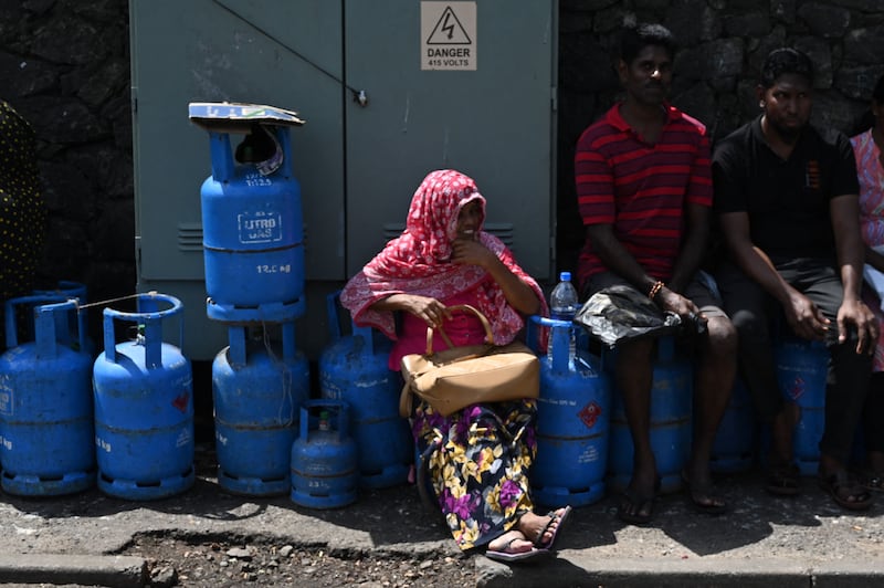 People wait in a queue to collect gas at a distribution point in Colombo. AFP