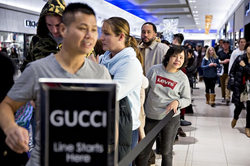 Shoppers wait in line outside a Gucci store at the Fashion Outlets of Chicago mall. Daniel Acker / Bloomberg