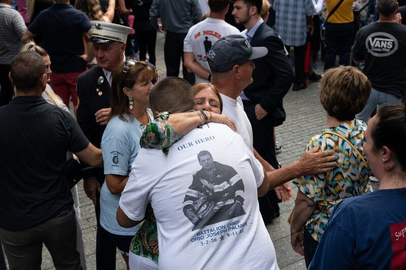 People embrace at the National September 11 Memorial. EPA