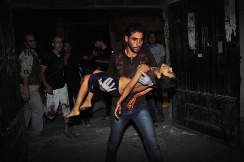 A Syrian man carries badly wounded five-year-old Mohammed Amumrej after he was hurt during shelling by Syrian government forces in the center of Syria's restive northern city of Aleppo late on July 25, 2012. The boy later died. Syrian troops and rebels sent reinforcements to the intensifying battle in the second city Aleppo, as the US said fresh defections from the regime showed President Bashar al-Assad's "days are numbered".  AFP PHOTO / BULENT KILIC

