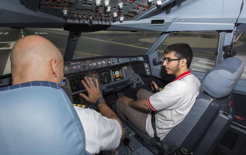 A student tries his hand at the cockpit controls during a simulated flight to Abu Dhabi International Airport, guided by an Etihad Airways captain. Courtesy Etihad