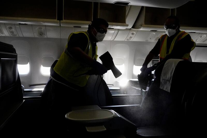 Workers with ABM Industries give a demonstration on cleaning inside a United Airlines plane destined for Hawaii at San Francisco International Airport in San Francisco. AP Photo