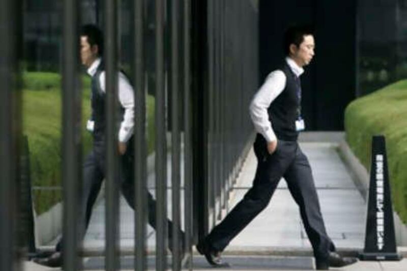 A businessman walks out of a building in Tokyo November 17, 2008. Japan slid into its first recession in seven years in the third quarter as the financial crisis curbed demand for Japanese exports, and the economy minister and analysts offered little hope of a recovery until next year.

 REUTERS/Yuriko Nakao (JAPAN) *** Local Caption ***  TOK301_FINANCIAL-JA_1117_11.JPG