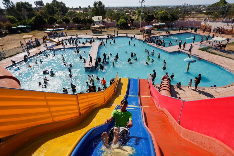 Palestinian people play inside a swimming pool to cool down during a hot weather, in Khan Younis in the southern Gaza Strip July 20, 2022.  REUTERS / Ibraheem Abu Mustafa