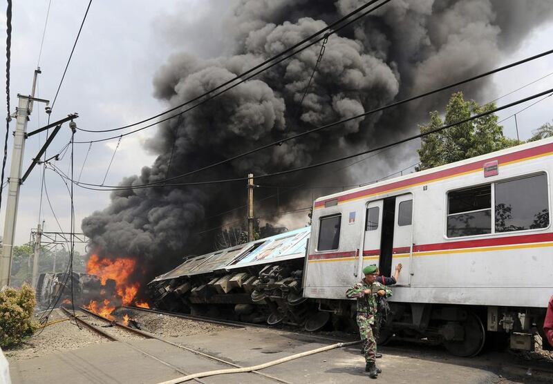 An Indonesian soldier walks away from an inferno after a commuter train collided with a lorry hauling fuel on the outskirts Jakarta, Indonesia. Tatan Syuflana / AP Photo