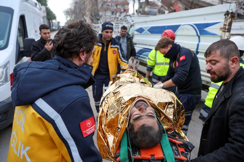 An injured man is carried to an ambulance after being rescued from the rubble in Hatay. Reuters