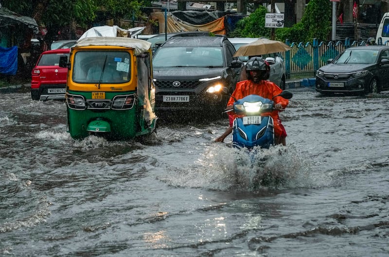 Vehicles move through a waterlogged street in Kolkata. Flights resumed at the city's airport on Monday after 20 hours, but train services are still disrupted AP