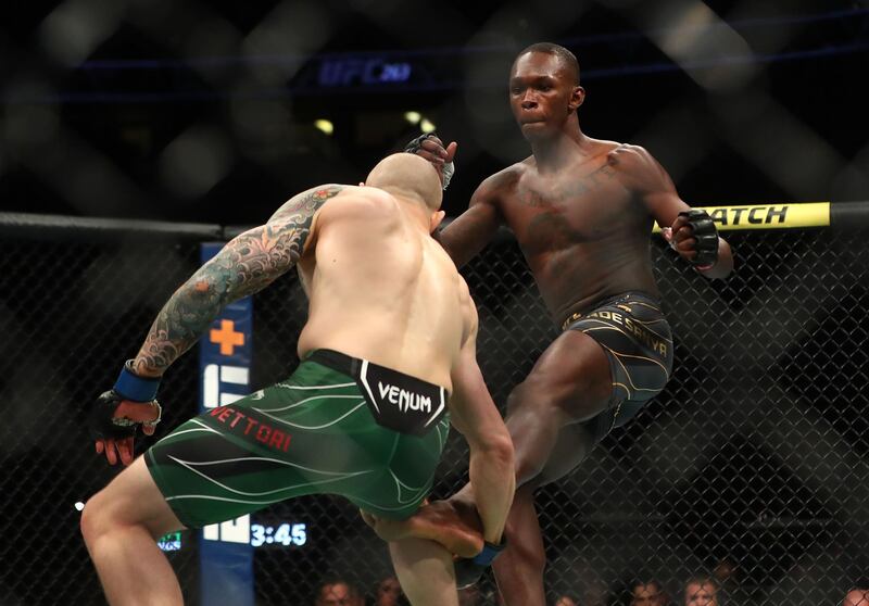 Israel Adesanya moves in with a kick as Marvin Vettori defends.