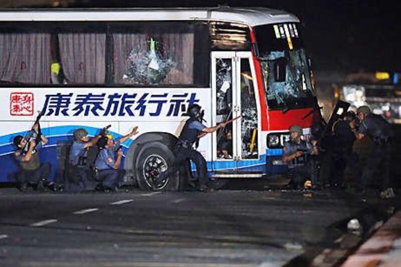 Police try to open the door of the tourist bus hijacked in Manila.