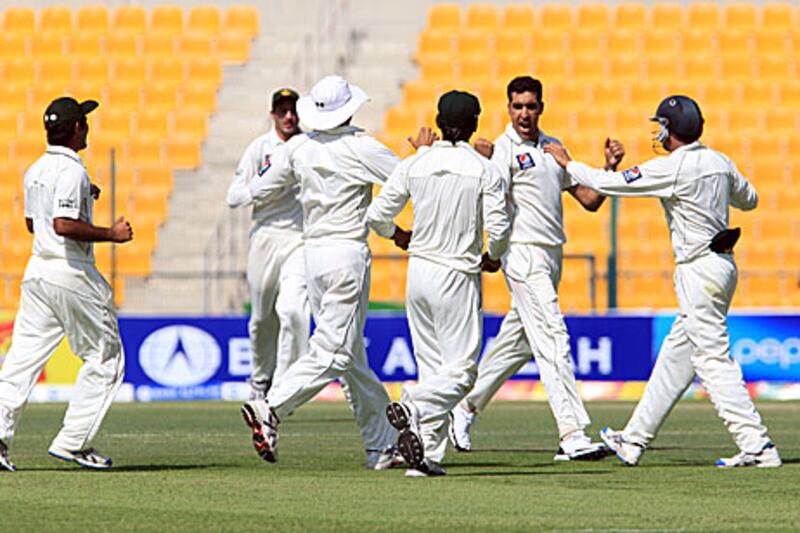 Umar Gul, second right, celebrates with Pakistan teammates after taking the wicket of Tharanga Paranavitana for 37 as Sri Lanka collapsed in the mid-session on the first day of the first Test in Abu Dhabi.