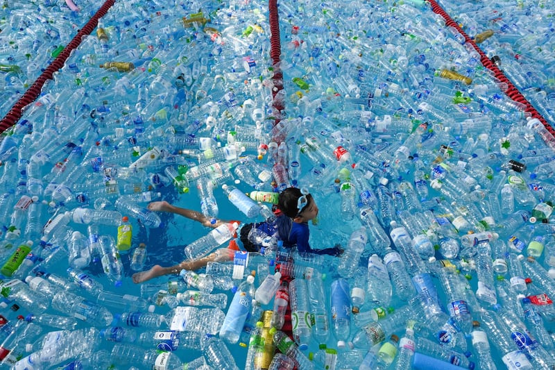 A child swims in a pool filled with plastic bottles during an awareness campaign to mark the World Oceans Day in Bangkok. AFP