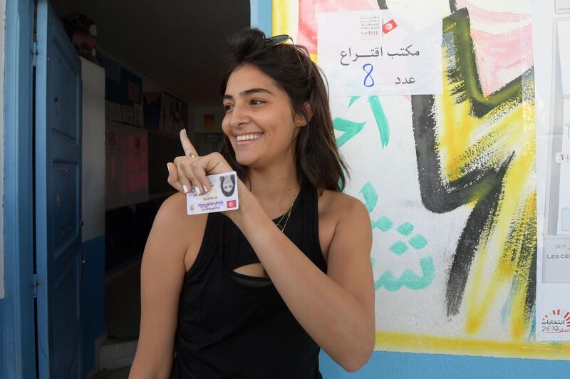 A Tunisian woman displays her ink-stained finger after casting her ballot at a polling station in the capital Tunis on October 6, 2019, during the third round of legislative elections since the North African country's 2011 revolution.  Some seven million voters are expected to head to polling stations, just weeks after the first round of the presidential polls swept aside the post-Arab Spring political establishment.  / AFP / FETHI BELAID
