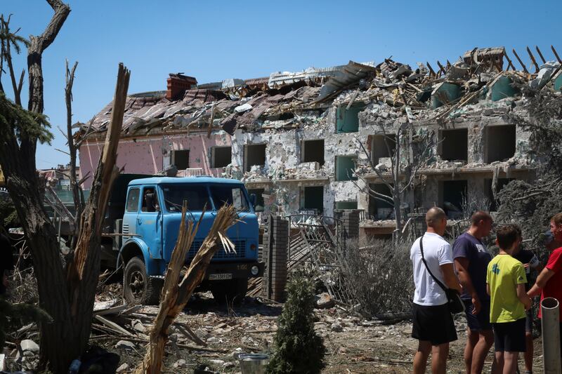 Local residents stand next to a damaged residential building in the town of Serhiivka, about 50 kilometres south-west of Odesa, Ukraine. AP