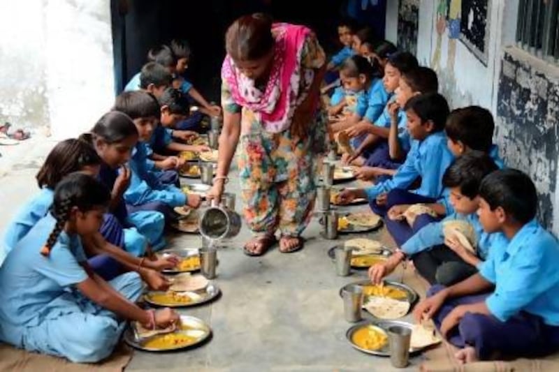 Indian schoolchildren eat their free midday meal at a government school in Amritsar on Friday.