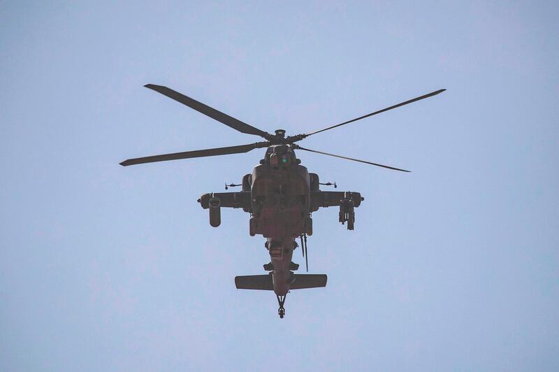 A US Apache attack helicopter flies over a field near the town of Tal Haddad in the countryside of Syria's Hassakeh province on September 15, 2020.  AFP