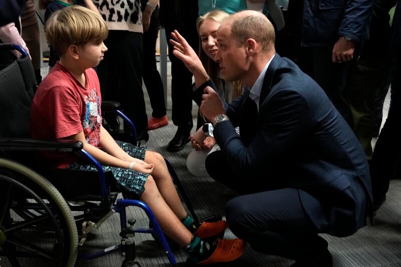 Prince William talks to a young boy as he visits the accommodation centre for Ukrainians. AP