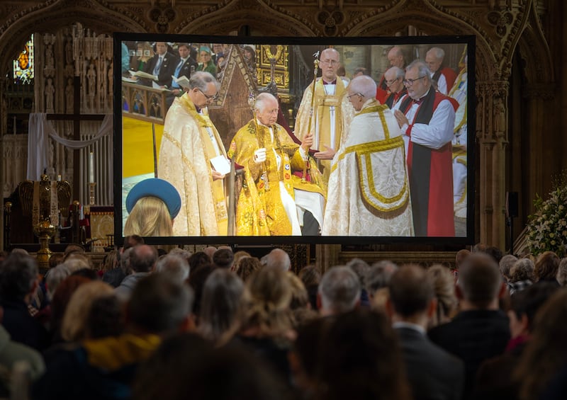 People watch the coronation on a big screen at  Bristol Cathedral. EPA