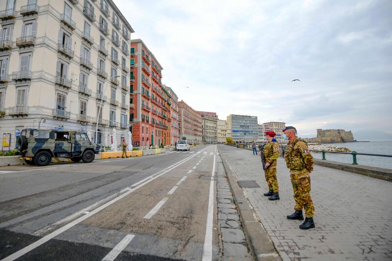 Army soldiers patrol an empty promenade towards Castel dell'Ovo castle, in Naples, southern Italy, on the first day after being declared a red zone. AP Photo