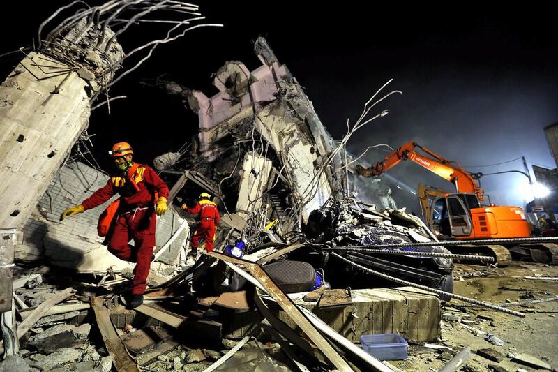 Rescuers remove debris as they continue to search for survivors from a collapsed building following a 6.4 magnitude earthquake that struck the area in Tainan, south Taiwan. Ritchie B Tongo / EPA