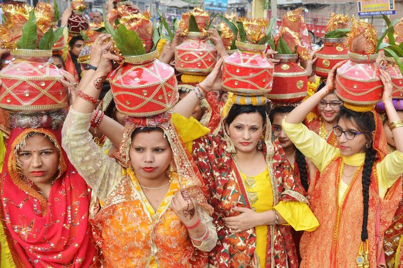 Indian Hindu devotees carry earthen pots containing sacred water with a coconut on top as they take part in a traditional religious procession known as 'Kalash Yatra', in Amritsar. AFP