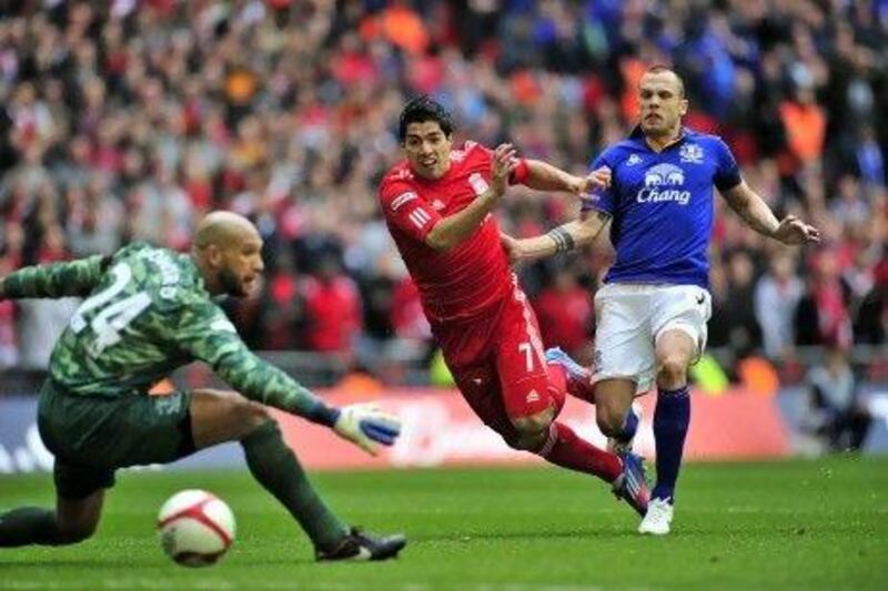 TOPSHOTS
Liverpool's Uruguayan striker Luis Suarez (2nd R) scores past Everton's US goalkeeper Tim Howard (L) during the FA Cup semi-final football match between Everton and Liverpool at Wembley Stadium in London, England on April 14, 2012. AFP PHOTO/GLYN KIRK 
 
NOT FOR MARKETING OR ADVERTISING USE / RESTRICTED TO EDITORIAL USE