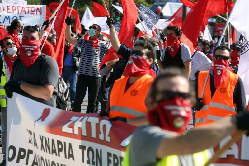 Members of the PAME movement and the KKE are holding flags, wear gloves and masks to protect themselves, and keep their distance from the rally for Labor Day on the Syntagma square in Athens, Greece.  EPA