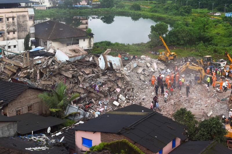 A rescue worker searches for people in the rubble of a collapsed five-storey apartment building in Mahad, about 170 kilometres from India's financial capital of Mumbai.  AFP