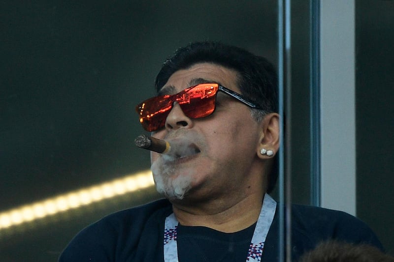 In this file picture taken on June 16, 2018 Argentina football legend Diego Maradona smokes a cigar as he attends the Russia 2018 World Cup Group D football match between Argentina and Iceland at the Spartak Stadium in Moscow. AFP