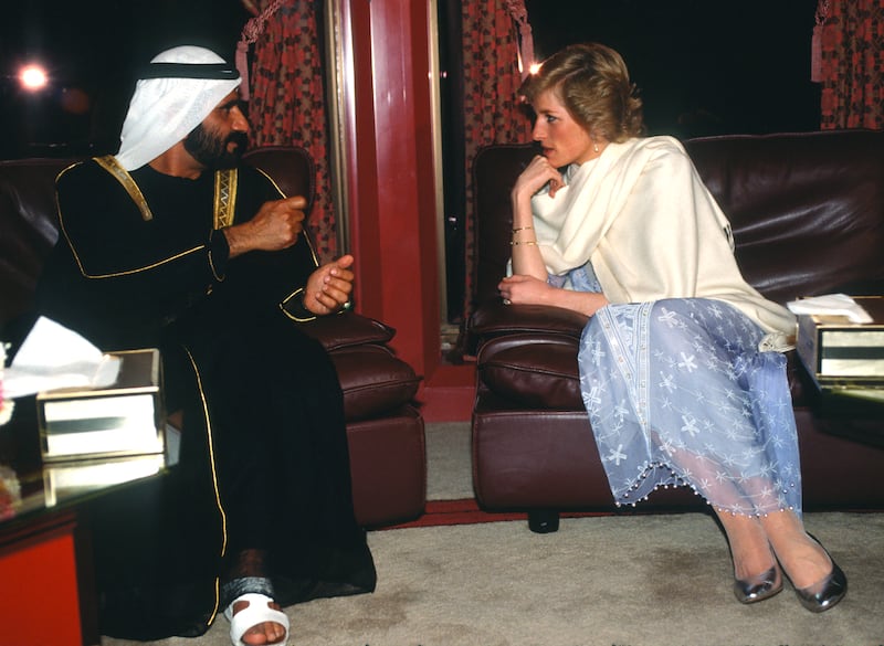 The princess, wearing a purple dress designed by Zhandra Rhodes, a white shawl and silver shoes, speaks to Sheikh Mohammed bin Rashid during a reception at the British Consulate in Dubai on March 16, 1989. 