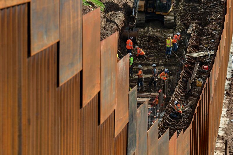 Workers reinforce a section of the US-Mexico border fence, as seen from Tijuana. AFP Photo