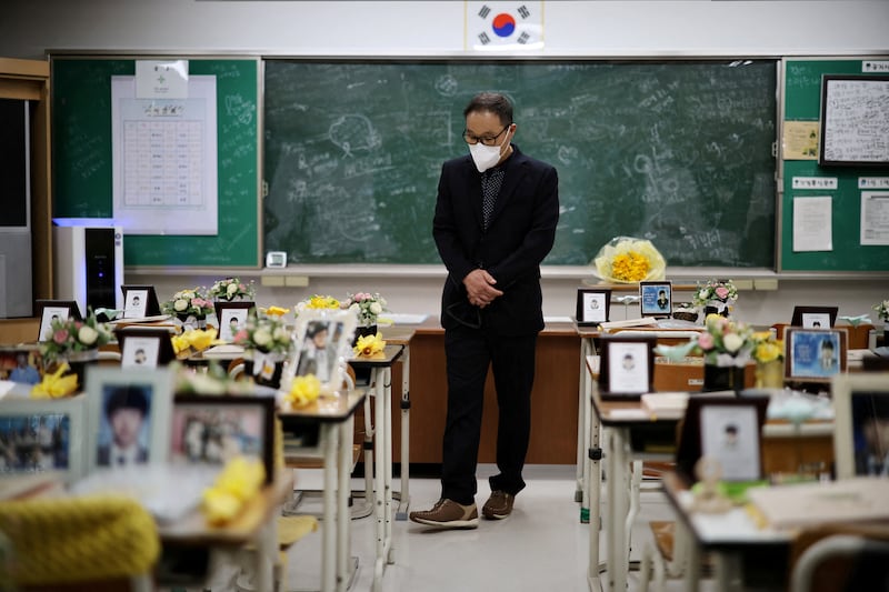 A man takes a look around a replica classroom filled with images of pupils who died in the 2014 Sewol ferry disaster, in Ansan, South Korea. Reuters
