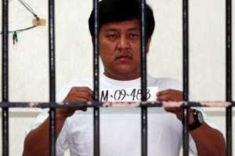 Andal Ampatuan Jr., a town mayor suspected in Monday's massacre, of Unsay township, Maguindanao province in southern Philippines, holds his detainee number while being photographed inside his detention cell at the National Bureau of Investigation (NBI) in Manila Friday Nov. 27, 2009. Ampatuan Jr. is the prime suspect in the massacre Monday of 57 people, including 22 journalists, at Maguindanao province in southern Philippines in what the president's office called the worst political violence in recent history. (AP Photo/Bullit Marquez) *** Local Caption ***  XBM101_Philippines_Hostages_Killed.jpg