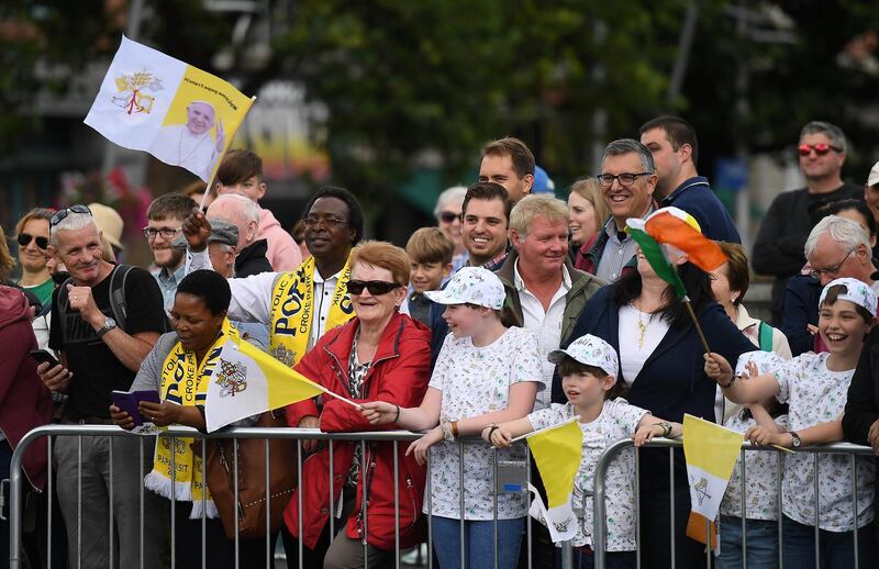 People wave at Pope Francis as he drives by. Reuters