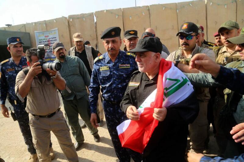 
                  <p>Iraq's Prime Minister Haider al-Abadi, center, holds a national flag upon his arrival to Mosul, Iraq, Sunday, July 9, 2017. Backed by the U.S.-led coalition, Iraq launched the operation to retake Mosul from Islamic State militants in October. (Iraqi Federal Police Press Office via AP)</p>
               