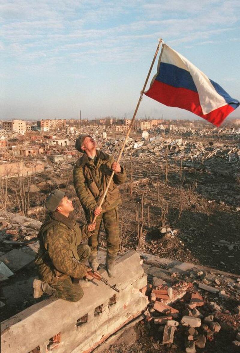 Russian soldiers raise a flag over the ruins of an apartment building in Grozny, Chechnya, in March 2000. AP Photo.