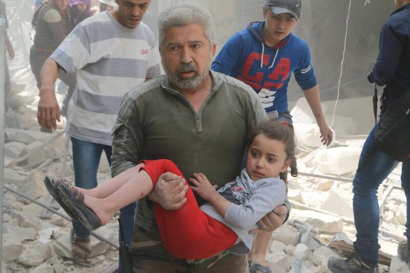 An injured girl is carried to safety after an air strike on a rebel-held area of Aleppo, Syria, on April 22, 2016. Abdalrhman Ismail / Reuters