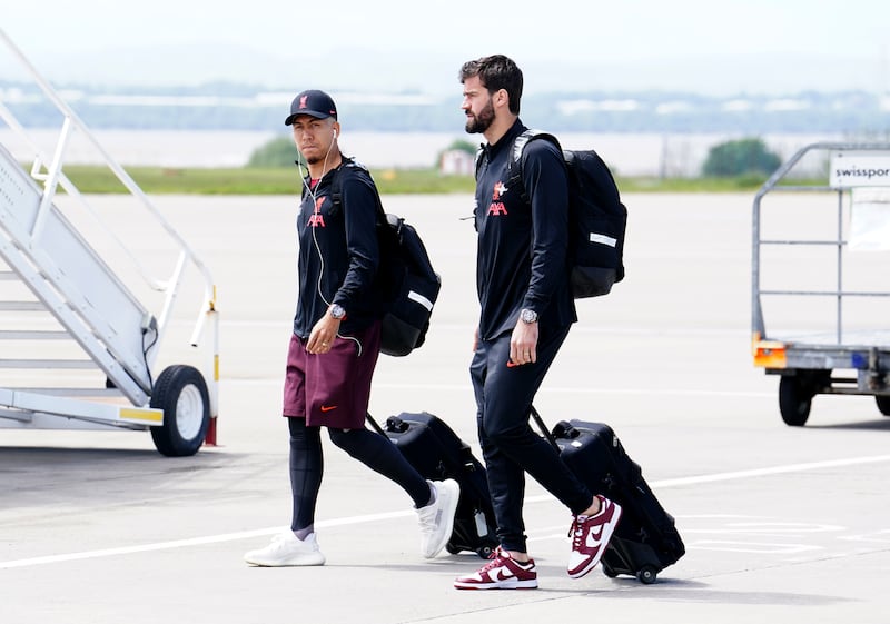 Liverpool's Roberto Firmino and goalkeeper Alisson board the plane at John Lennon Airport. PA