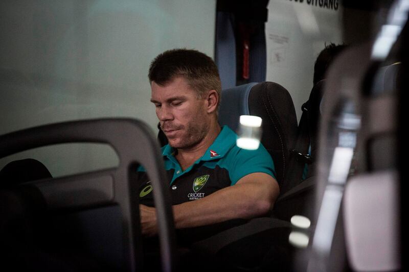 Former vice-captain David Warner of the Australian Cricket Team sits in the shuttle bus as he arrives at OR Tambo International Airport after the team was caught cheating in the Sunfoil Test Series between between Australia and South Africa on March 27, 2018.  / AFP PHOTO / GULSHAN KHAN