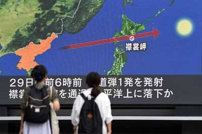 Pedestrians watch the news on a huge screen displaying a map of Japan (R) and the Korean Peninsula, in Tokyo on August 29, 2017, following a North Korean missile test that passed over Japan.
Japanese Prime Minister Shinzo Abe said on August 29 that he and US President Donald Trump agreed to hike pressure on North Korea after it launched a ballistic missile over Japan, in Pyongyang's most serious provocation in years. / AFP PHOTO / Toshifumi KITAMURA