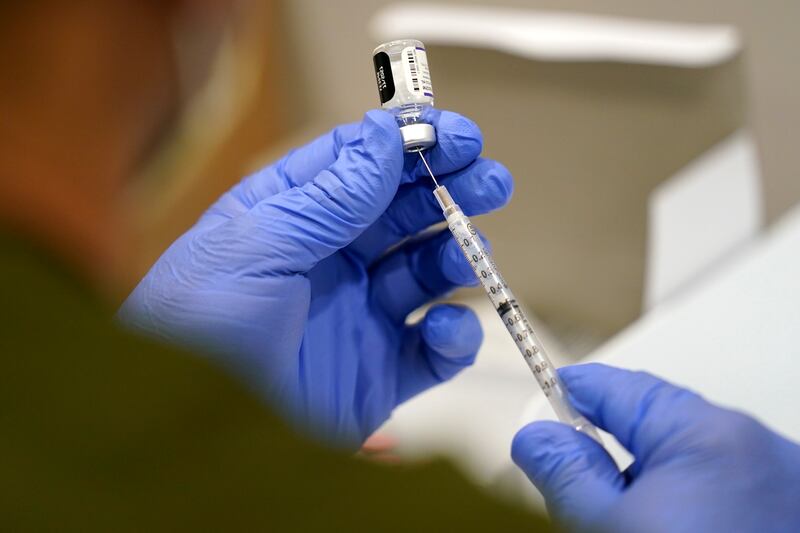 A healthcare worker fills a syringe with the Pfizer Covid-19 vaccine. AP Photo