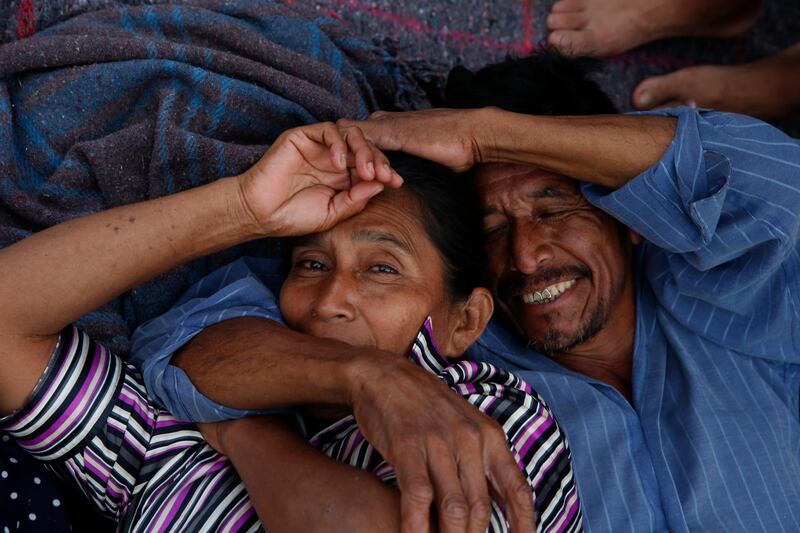 A migrant couple lie on the ground as members of the caravan stop for the night in Niltepec, Oaxaca state, Mexico. AP Photo